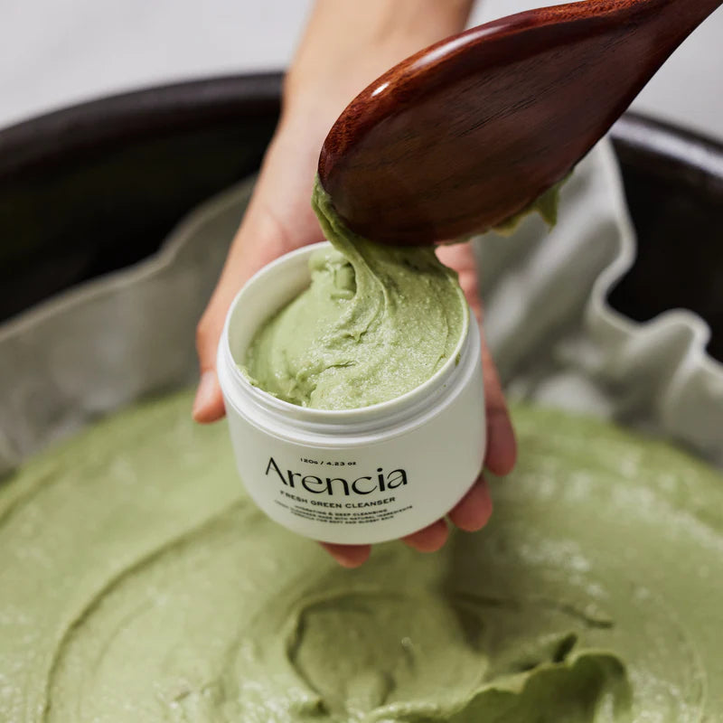 Arencia Fresh Green Rice Mochi Cleanser being scooped with wooden spoon showing rich green formula